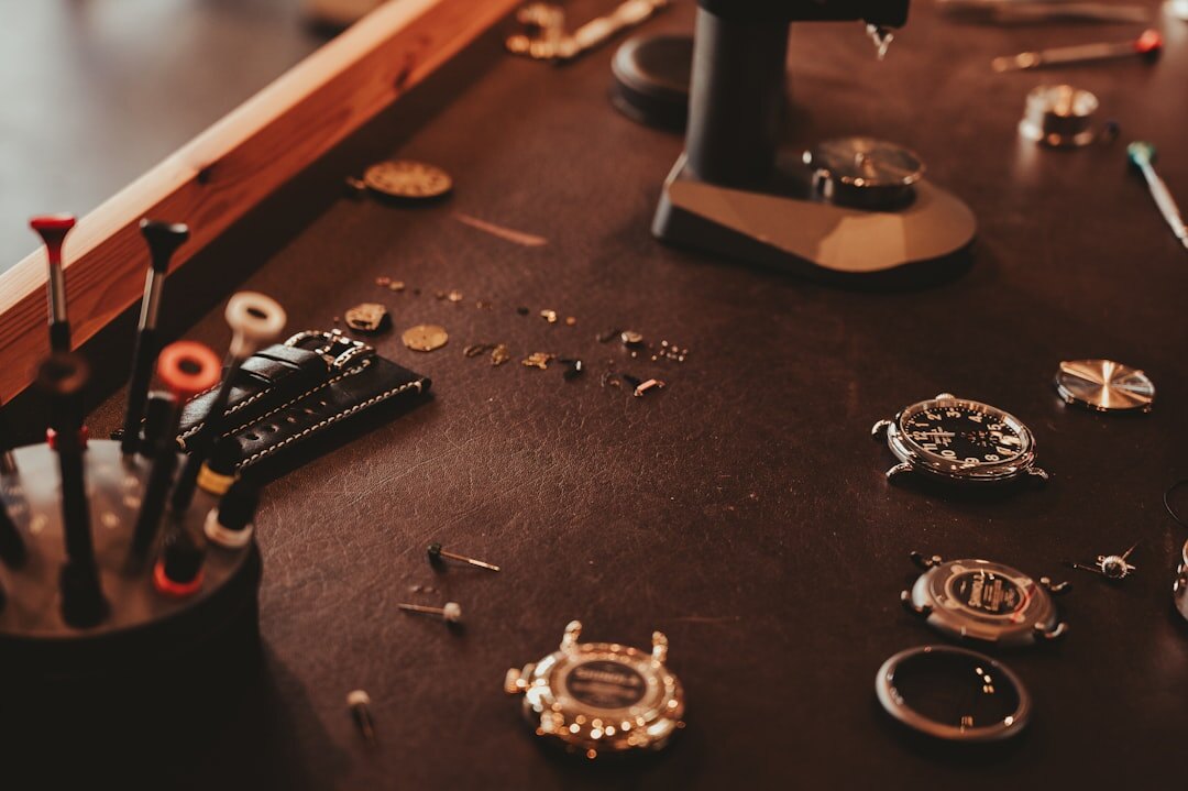 Watchmaker hands assembling a mechanical movement with tools